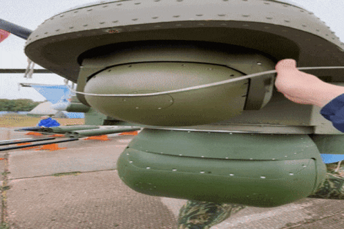 a person is holding a green object that looks like a spaceship