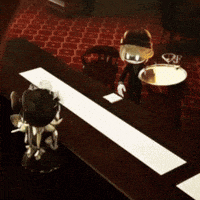 a cartoon character sitting at a table with a bowl of food
