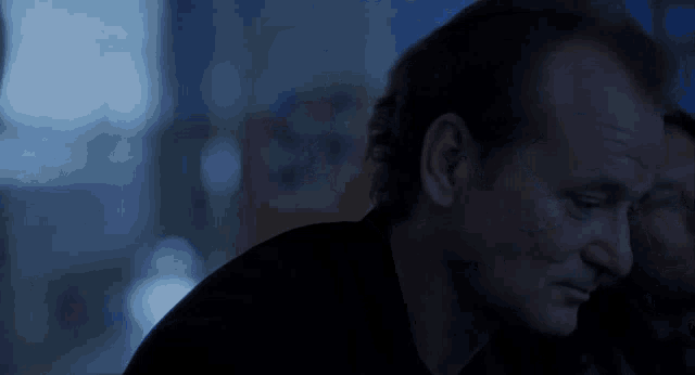 a close up of a man 's face in a dark room