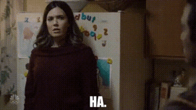 a woman is standing in front of a refrigerator with the word ha written on it
