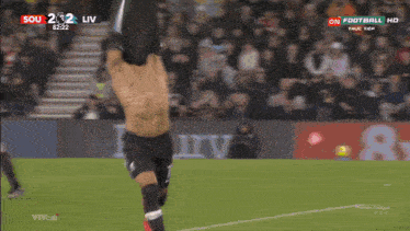 a shirtless soccer player celebrates a goal during a match