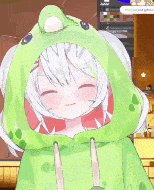 a girl wearing a green frog hoodie is smiling and says thejred just gifted