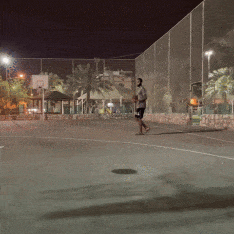 a man stands on a basketball court at night