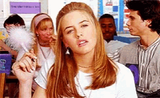 a girl in a white shirt is holding a pink pen