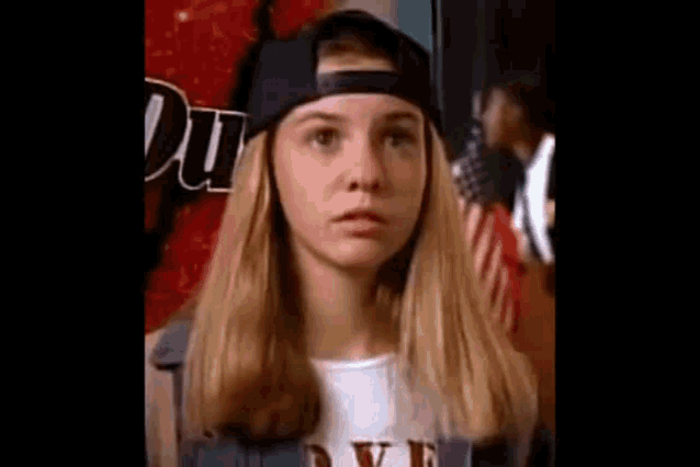 a young woman wearing a baseball cap and a t-shirt .