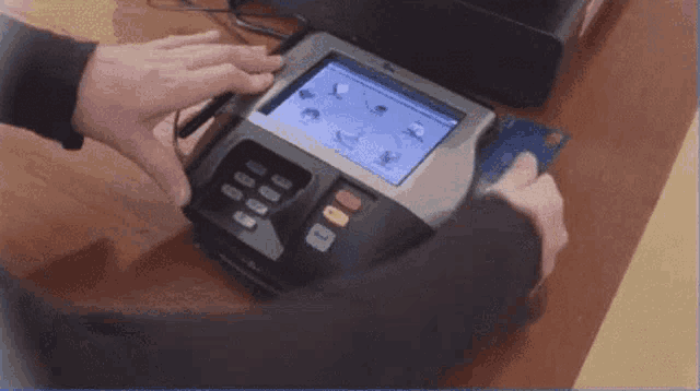 a person is holding a credit card in front of a machine that says visa