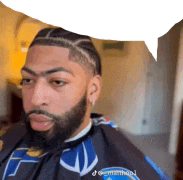 a man with a beard and braids is wearing a cape