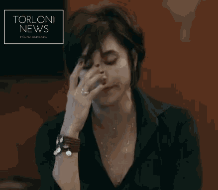 a woman talking on a cell phone with a torloni news advertisement in the background