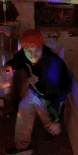 a blurry picture of a person with red hair dancing in a dark room