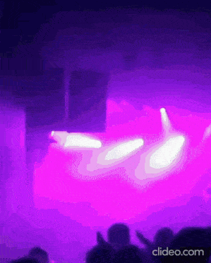 a blurry photo of a stage with purple lights and the words clideo.com below it