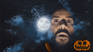a man wearing a skeleton hoodie stands in front of a full moon