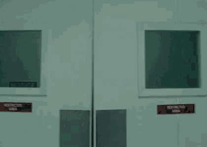 a man is peeking out of a door in a room .