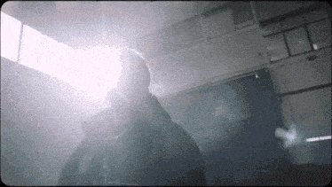 a man in a black jacket is standing in a dark room