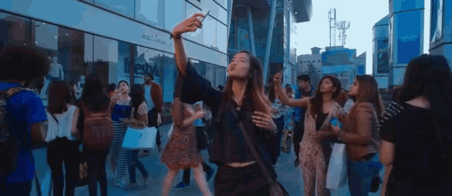 a woman taking a selfie in front of a building that says ' abercrombie & fitch '