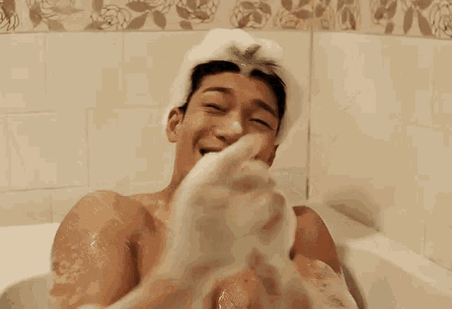 a man is taking a bath in a bathtub filled with foam .