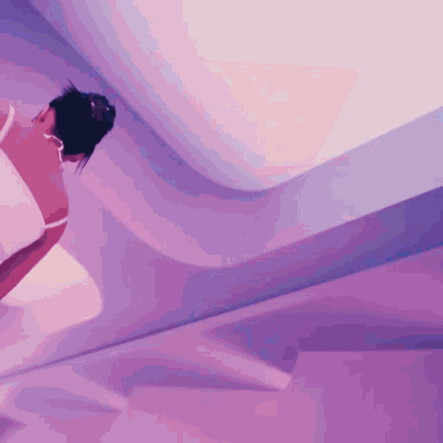 a woman in a white dress is standing in a room with purple lights