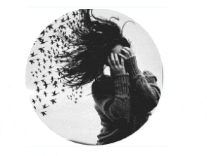a black and white photo of a woman with birds flying around her head