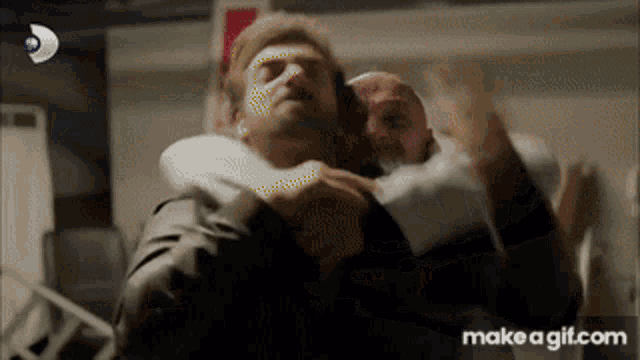 a man is carrying another man on his back in a hospital room .