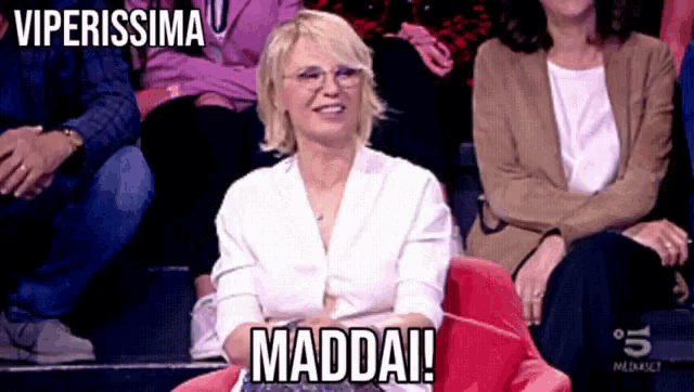 a woman is sitting in a chair with the words maddai written on her face