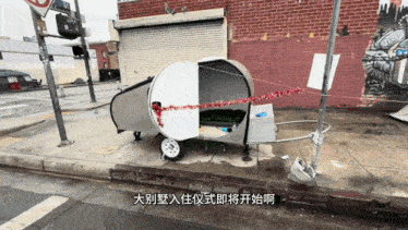 a trailer with chinese writing on it is parked on a sidewalk
