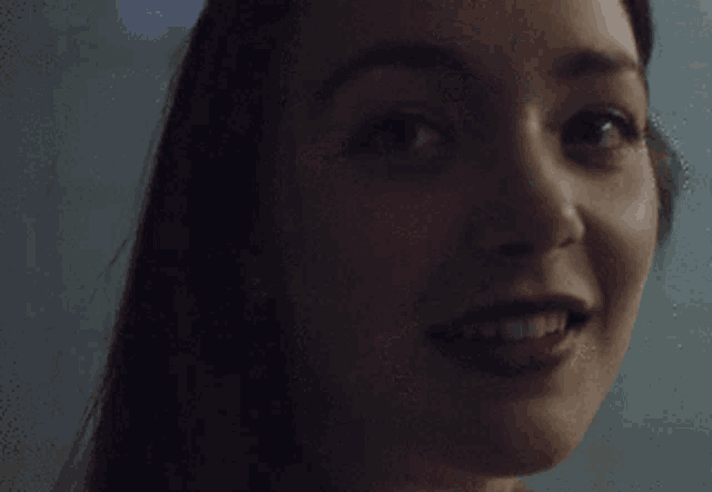 a close up of a woman 's face with her mouth open and looking at the camera .