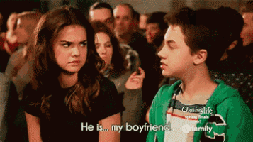 a girl says he is my boyfriend in front of a boy in a green hoodie