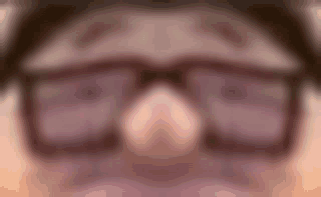 a blurry picture of a person wearing glasses .