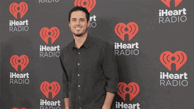 a man stands in front of a iheart radio wall