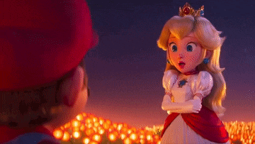 a princess peach doll is standing next to a man in a red hat .