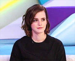 a woman with short hair is wearing a black top