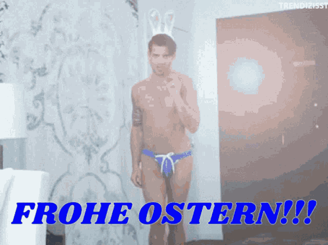 a man in bunny ears is standing in front of a sign that says frohe ostern !!!
