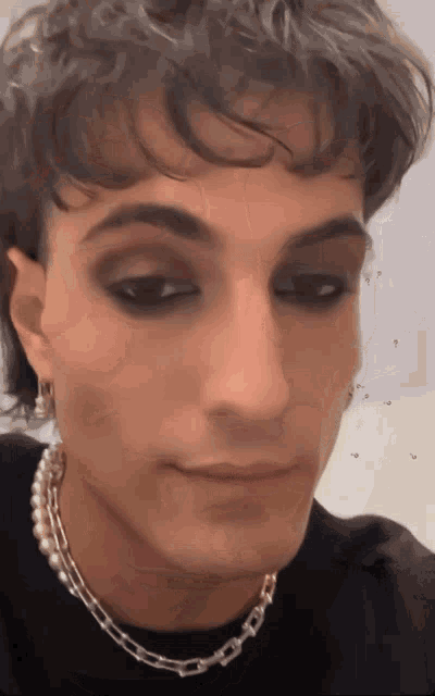 a close up of a person 's face with a pearl necklace