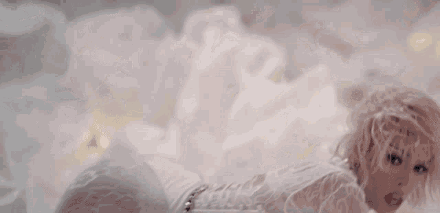 a woman in a white lace bodysuit is laying on the floor