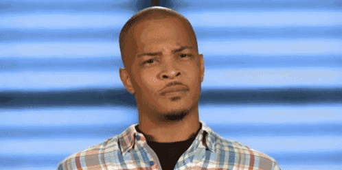 a man in a plaid shirt is making a face