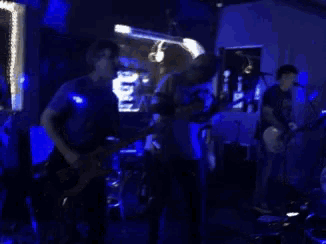 a group of men playing guitars and singing into microphones on a stage