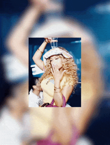a blurry picture of a woman holding a glass of water on her head