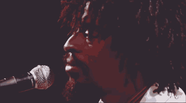 a man singing into a shure microphone with his eyes closed