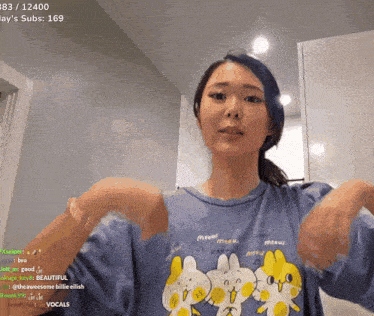a woman wearing a blue shirt with meow written on it