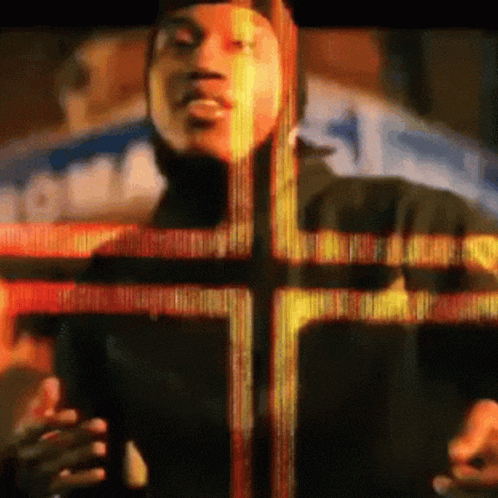 a man is standing in front of a cross with a blurred background