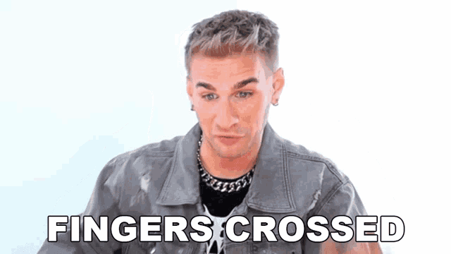 a man in a denim jacket is pointing up with the words fingers crossed above him