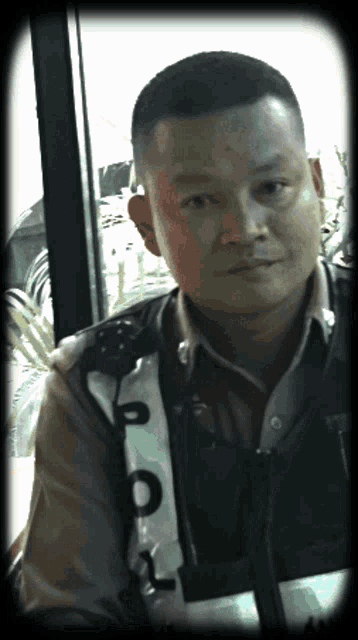 a man wearing a vest with the letter p on it is looking at the camera