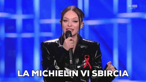 a woman singing into a microphone with the words la michelin vi sbircia written below her