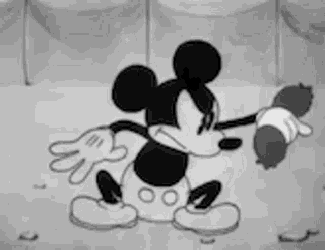 a black and white cartoon of mickey mouse holding a baby in his hands .
