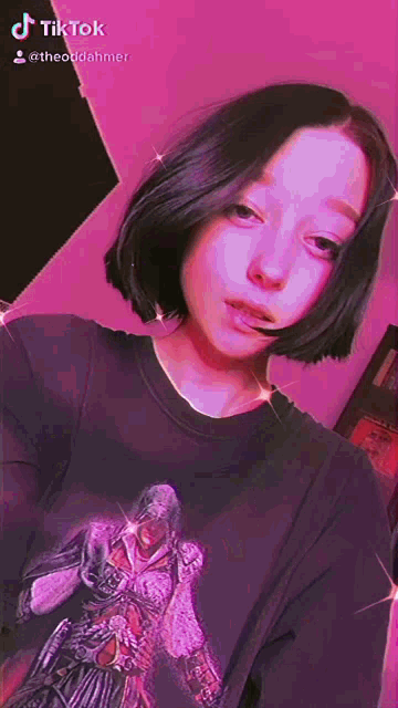 a girl with short hair is wearing a black shirt with a picture of a person on it