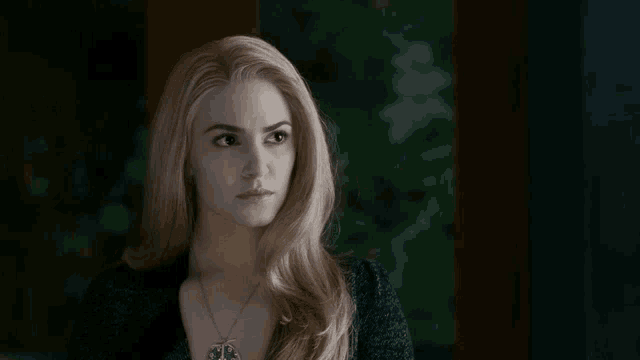 a woman with blonde hair and a necklace on her neck
