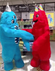 a blue monster and a red monster wearing party hats are standing next to each other