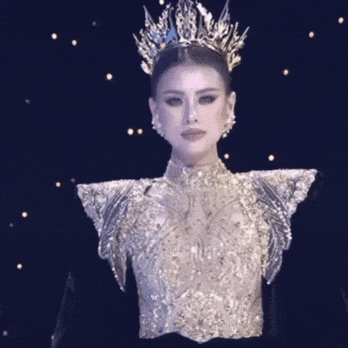 a woman is wearing a crown and a very elaborate dress