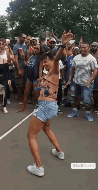 a man in shorts is dancing in front of a crowd with the hashtag ancherunshe on the bottom
