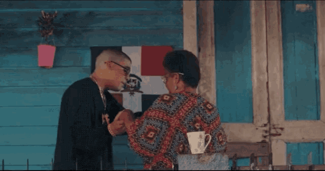 a man holds a woman 's hand in front of a flag that says ' dominican republic ' on it