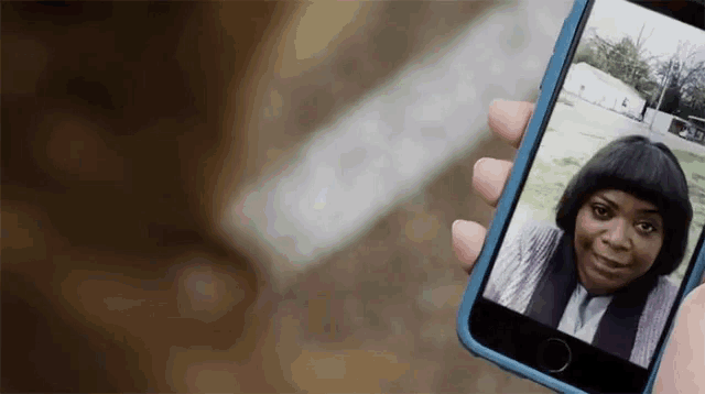 a person is taking a picture of a woman on their phone